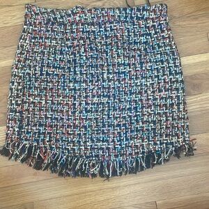 Woven mini skirt with metallic threads and fringed edge